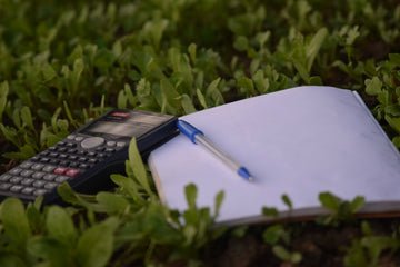 Calculator, pen and financial documents on a desk