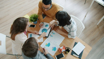 Business team reviewing charts and reports around a table
